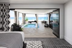 an open living room with a pool in the middle and black and white rugs on the floor