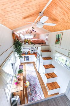 the interior of a tiny home with stairs leading up to the loft