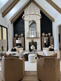 a living room filled with lots of furniture and a chandelier hanging from the ceiling