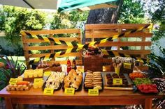 a wooden table topped with lots of different types of breads and pastries on top of it