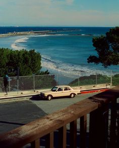 an old car is parked on the side of the road by the beach and ocean