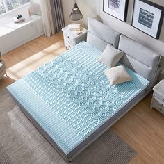 a bed in a bedroom with blue and white bedspread on top of it