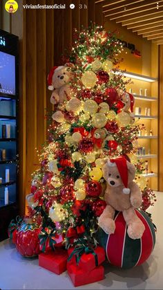 a teddy bear sitting on top of a christmas tree