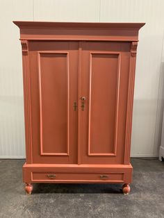 an orange armoire sitting on top of a cement floor