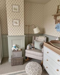 a baby's room with a crib, chair and dresser in it is shown