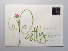 an envelope with the word pattis written in cursive writing and flowers on it