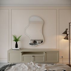 a bedroom with a large mirror on the wall next to a white dresser and bed