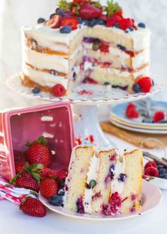 two slices of cake on plates with strawberries and raspberries