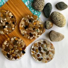 rocks and pebbles are arranged on a wooden board