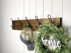 a wreath and hat hanger on a white wall