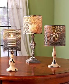 three lamps sitting on top of a wooden table