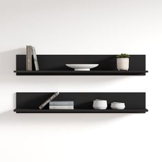 two black shelves with books and vases on them