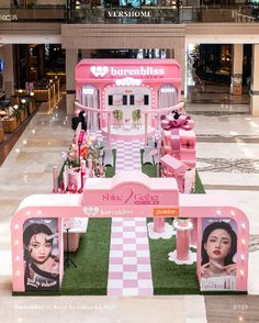 a display in the lobby of a shopping mall with pink decorations and lights on it