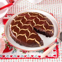 a chocolate cake on a plate with one slice cut out and ready to be eaten