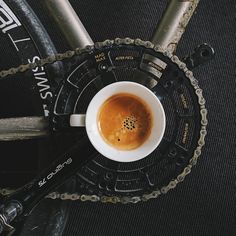 a cup of coffee sitting on top of a bike