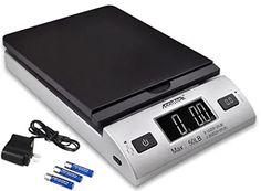 a digital scale with four batteries and two plugs in front of it, on a white background