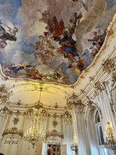 an ornate ceiling with paintings and chandeliers