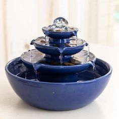 three blue bowls with water running down them