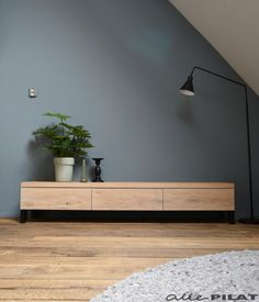 a plant is sitting on top of a wooden dresser