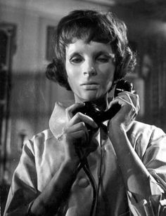 a woman is talking on the phone while wearing a collared shirt and necktie