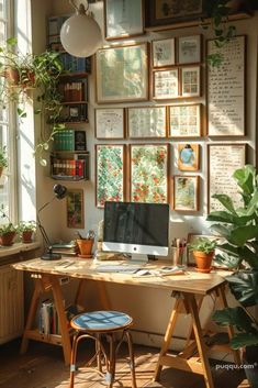 a desk with a computer on it in front of a window filled with books and plants