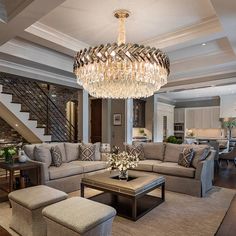 a living room filled with lots of furniture and a chandelier hanging from the ceiling