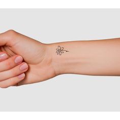 a woman's arm with a small flower tattoo on the left side of her arm