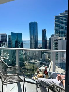 a man sitting on top of a balcony next to a table