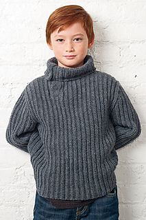 a young boy standing in front of a white wall with his hands on his hips