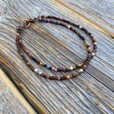 Tiny Red Creek Jasper Beaded Anklet or Bracelet: This boho chic ankle/bracelet is perfect for all occasions. The various shades of color make this a very versatile piece of jewelry that will go with many different outfits. Dress up or down! Materials: * Red Creek Jasper Beads - 2mm * Easy to Use Copper Lobster Clasp Choose your length at checkout! Matching Necklace: https://www.etsy.com/listing/960287596/small-beaded-necklace-red-creek-jasper Brown Gemstone Beads Bracelets For Festival, Brown Gemstone Beaded Bracelets For Festival, Festival Brown Beaded Bracelets With Gemstone, Festival Brown Gemstone Beaded Bracelets, Bohemian Brown Bracelet With Tiny Beads, Adjustable Double Strand Bracelet With Tiny Beads, Adjustable Double Strand Bracelets With Colorful Beads, Adjustable Double Strand Gemstone Beads Bracelet, Adjustable Double Strand Colorful Beads Bracelet