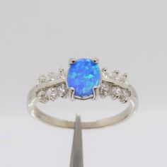 a white gold ring with an opal and diamonds