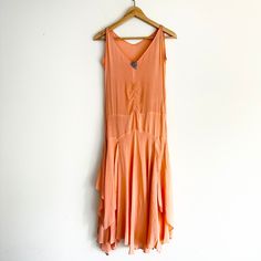 "Fabulous antique silk flapper dress Circa 1920's, very Gatsby! Peach/pink silk fabric, soft with lovely movement. V neckline with shoulder straps. Drop waist fit with delicate gathered details at waist. Handkerchief draped hems, asymmetrical. Unlined, not sheer. Side snap button closure, brand new snaps! Adorable Art Deco silver heart adorns neckline. One pinhole next to jewel at neckline. One corner of hem has a cut as shown, didn't notice until I looked over every inch! Overall structurally sound and wearable as is. Due to age and delicate nature of fabric, some general signs of wear are to be expected! Best fit size XS Bust flat 17\" Waist flat 14\" Hips flat 18\" Full length 47\"" 1920s Flapper Dress For Summer, 1920s Style Summer Flapper Dress, Silk Sleeveless Flapper Dress, Summer Silk Dress In Peach, Summer Peach Silk Dress, 1920s Style Silk Summer Dress, Pink Silk Fabric, Gatsby Art, Art Deco Silver