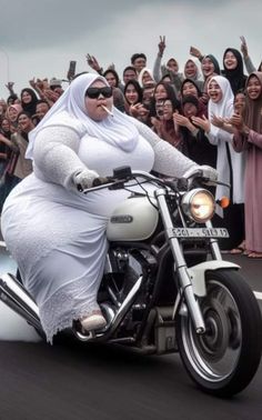 a large woman riding on the back of a motorcycle in front of a group of people