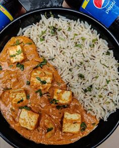 tofu, rice and beer are on the table next to each other in a bowl