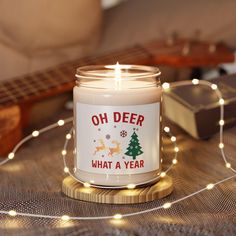 a lit candle sitting on top of a table next to a string of christmas lights