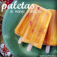 three popsicles on a green plate with the words paletass de mango y durazno