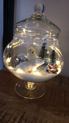 a glass bowl with some lights in it and a polar bear sitting on the bottom