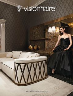 a woman in a black dress standing next to a white couch