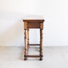 a small wooden table sitting on top of a white floor