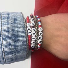 These Philadelphia Phillies themed beaded bracelets come in red, blue, or white and can say a variety of Phillies phrases or customize it to say something else! These bracelets are perfect for any Philly lovin gal or guy.  Please select size and style options in the personalization box. This bracelet is stretchy and made for the average-sized adult, if you need it to be larger or smaller please specify the size in inches in the notes section when purchasing.  IF you would like this style bracelet to say something else, check out our other listing below. https://www.etsy.com/listing/773122283/customized-name-bracelet?ref=shop_home_active_4  Feel free to reach out with any other questions or concerns! **Not recommended for children under 4 years old ** Red Novelty Beaded Bracelets For Friendship, Personalized Red Novelty Bracelets, Themed White Beaded Bracelets Gift, Themed White Beaded Bracelets For Gift, Personalized Themed Red Bracelets, Themed Personalized Red Bracelets, Themed Red Bracelet For Friendship, Adjustable White Themed Stretch Bracelet, Handmade Red Beaded Bracelets In Novelty Style