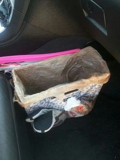 an empty bag sitting in the back seat of a car next to a pink toothbrush