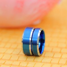 two blue and silver rings sitting on top of a table