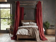 a bed with red drapes and pillows in a room