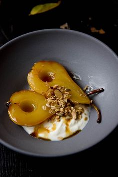 two pieces of fruit and yogurt in a gray bowl on a black table