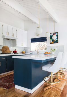 a kitchen with blue cabinets and white counter tops is featured on the instagram page