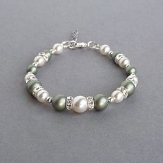 Dusty green and white Swarovski pearls have been combined with rings of Swarovski crystals to create these sage green pearl bracelets. Perfect gifts for bridesmaids in a celadon themed wedding. Each olive pearl and crystal bracelet measure 7 inches / 17.75cm in length and is finished with a silver plated lobster clasp. I have added a 1 inch extension chain to allow the wearer to adjust their single strand, celadon bracelet to fit. Your pistachio coloured jewellery will be carefully gift wrapped Dusty Green Wedding, Jewellery For Bridal, Green Pearl Jewelry, Green Wedding Jewelry, Bridesmaid Bracelets, Gifts For Bridesmaids, Green Themed Wedding, Jewelry King, Pearl Bracelets