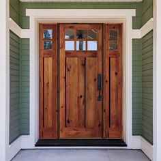 the front door is made of wood and has two sidelights on either side of it