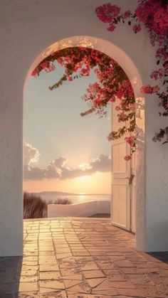 an open door with pink flowers on it and the sun setting in the distance behind