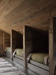 bunk beds are lined up against the wall in a room with wood paneled walls