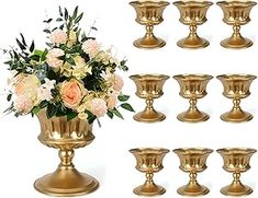 a bunch of gold vases with flowers in them